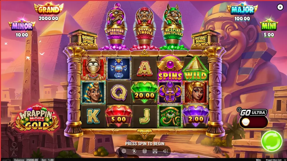 Tampilan visual slot Wrappin’ More Gold dengan mumi ramah dan latar belakang Mesir Kuno.